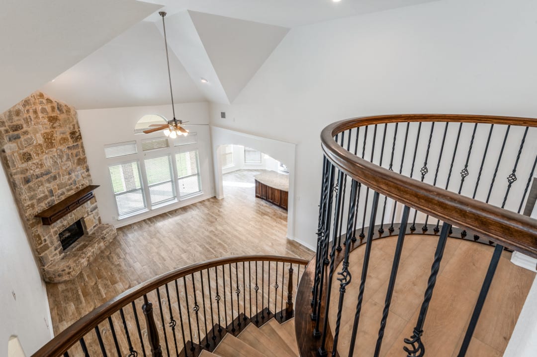 Curved staircase with wrought-iron balusters and wood treads