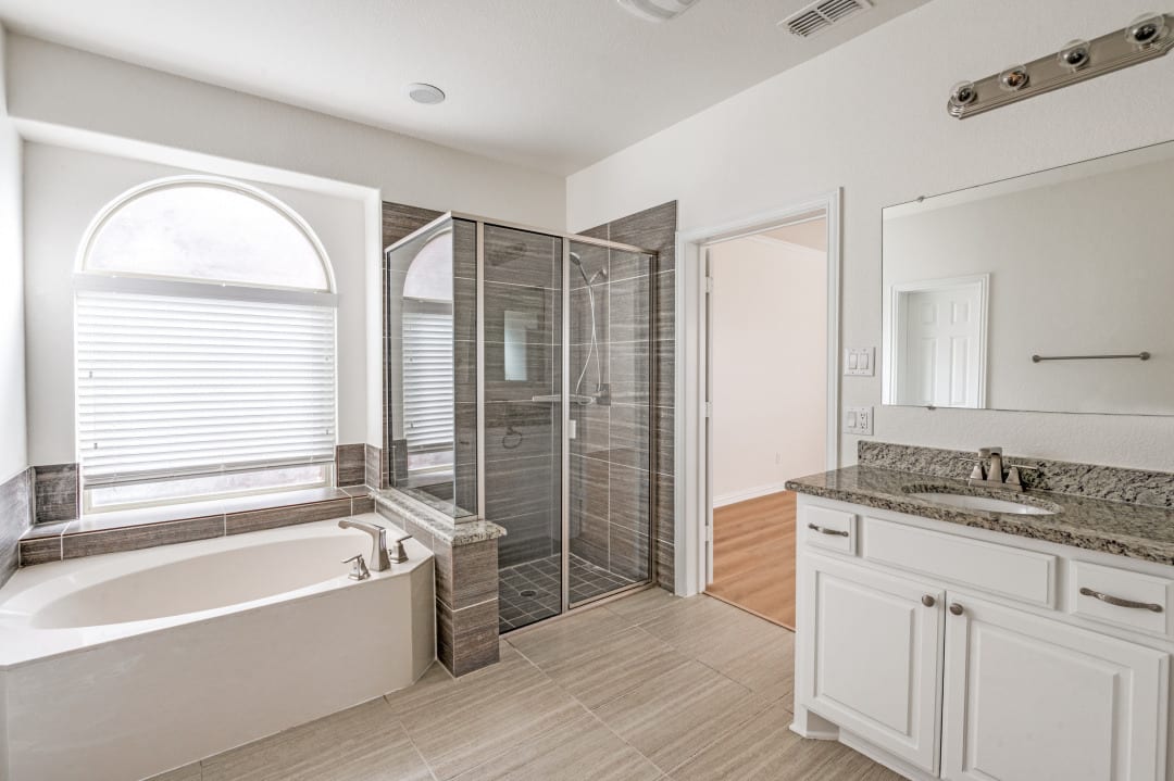 Master bathroom with garden tub, glass shower, and dual vanity