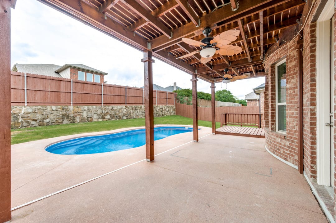 Covered patio overlooking a resurfaced backyard pool