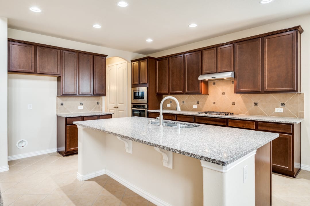 Kitchen remodel with granite island and stained wood cabinets