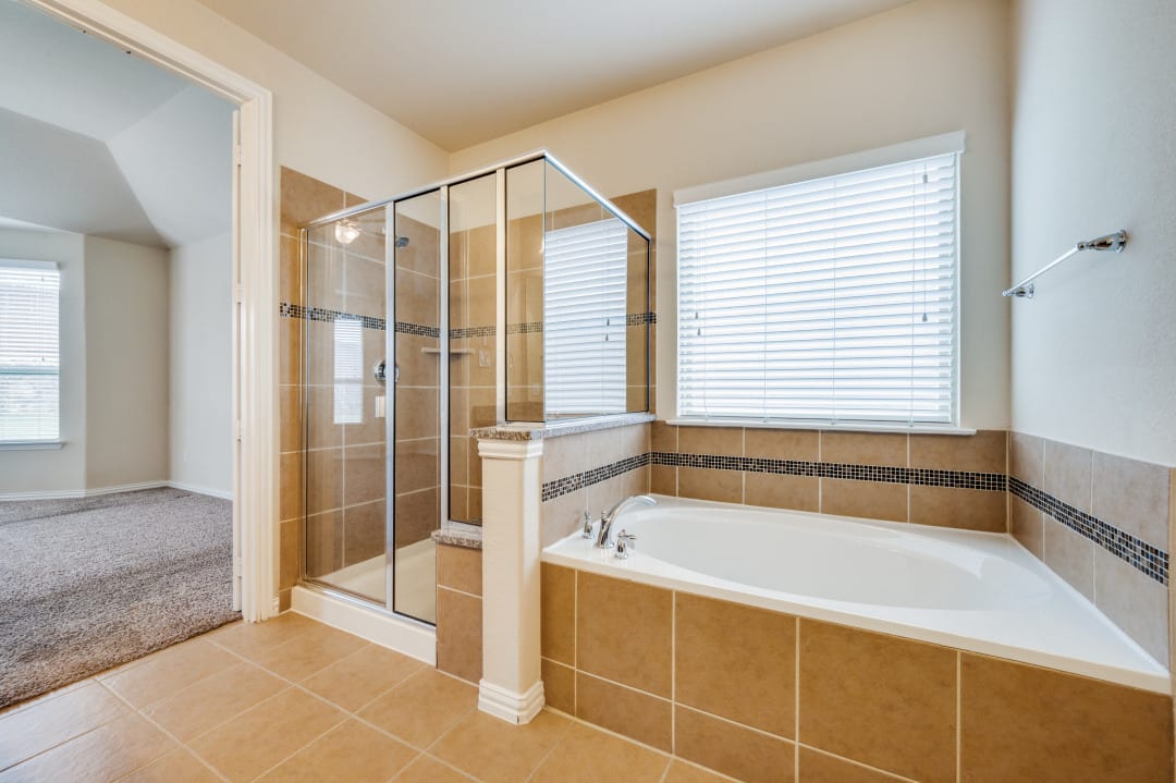 Spa-style master bath with soaking tub and frameless glass shower