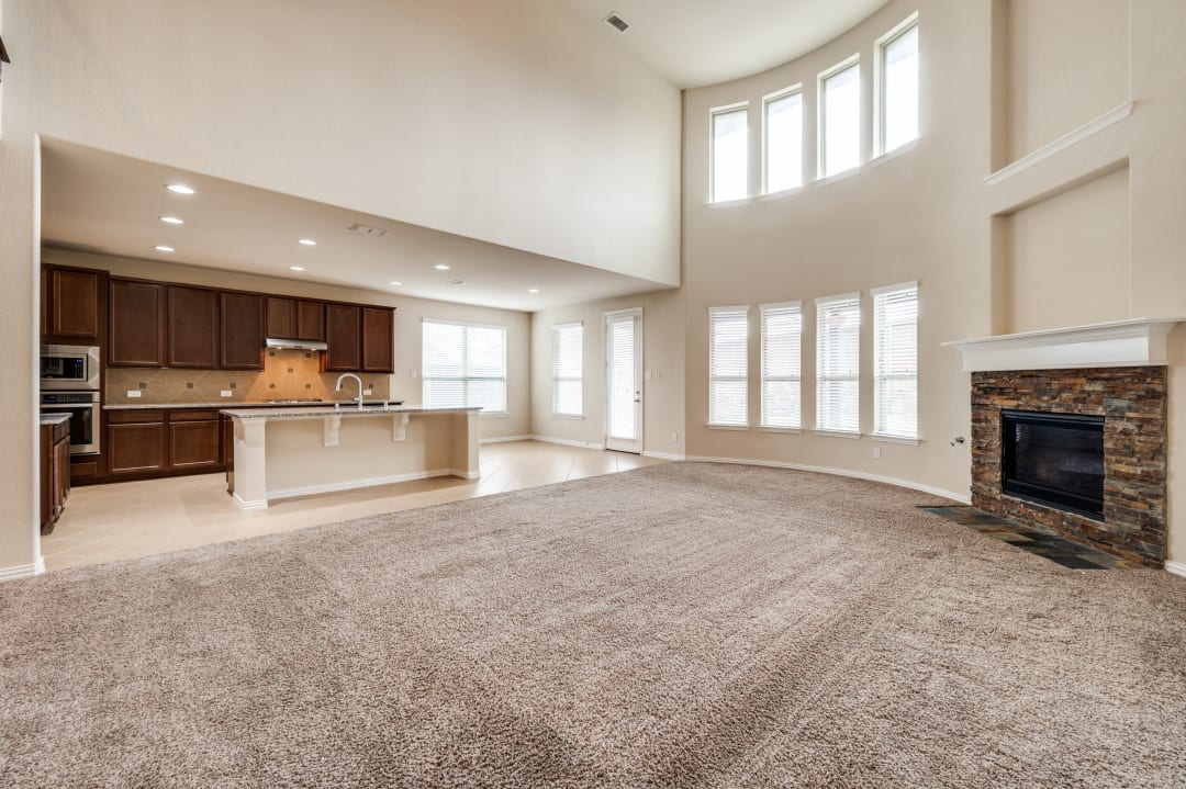 Two-story living room with fireplace and abundant natural light
