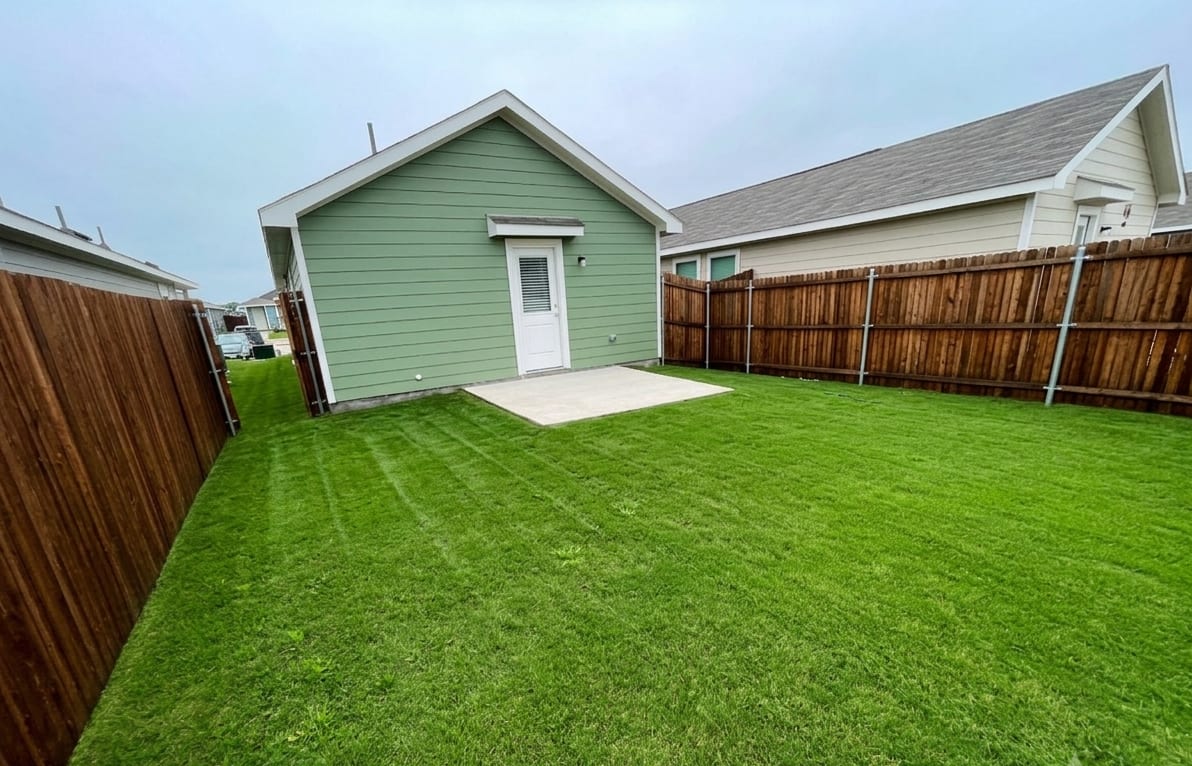 Backyard with newly laid sod and privacy fencing
