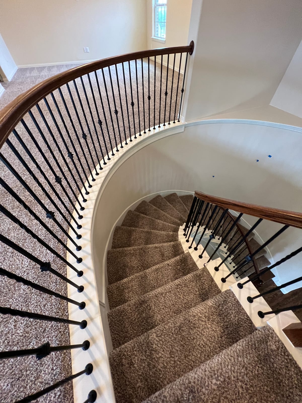 Spiral staircase with iron balusters in a whole-home renovation